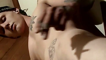 Tattooed Kyd Cash chainsmoking while working his cock in his boxer shorts