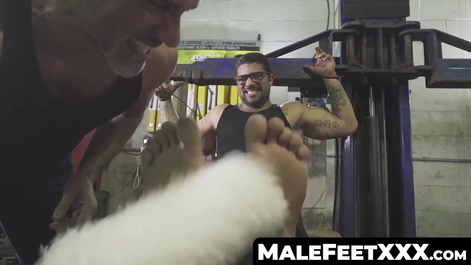 Bound tattooed hunk endures tickle torment from muscular master