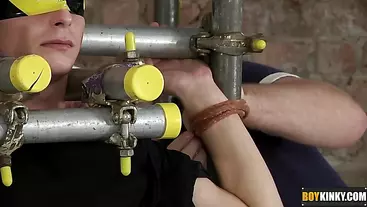 The boy is restrained in a cage of metal and blindfolded